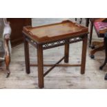 Mahogany tray top table with fretwork freeze, raised on four reeded legs to cross stretcher.