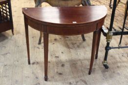 Mahogany inlaid with satinwood demi-lune card table raised on tapering legs.
