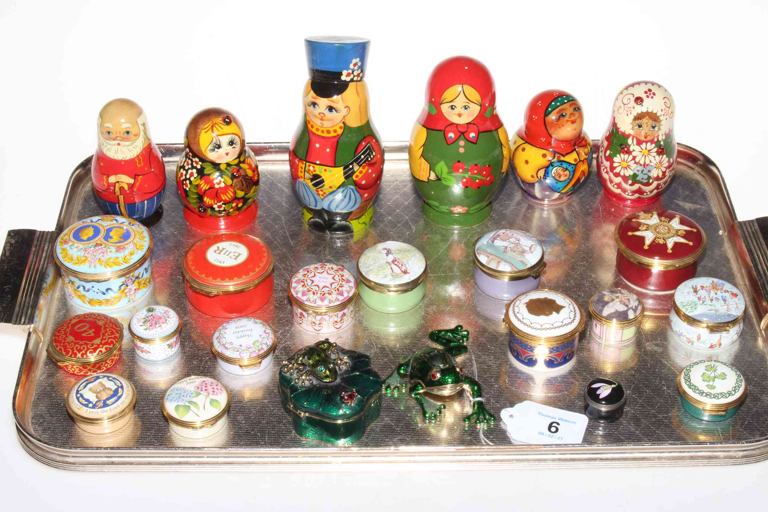 Sixteen enamel boxes including eight Halcyon Days, two Chinese frog boxes, and six Russian dolls.