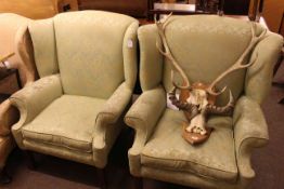 Pair of wing armchairs in green floral fabric.