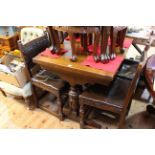 Oak draw leaf dining table on carved twin supports, with four studded leather chairs.