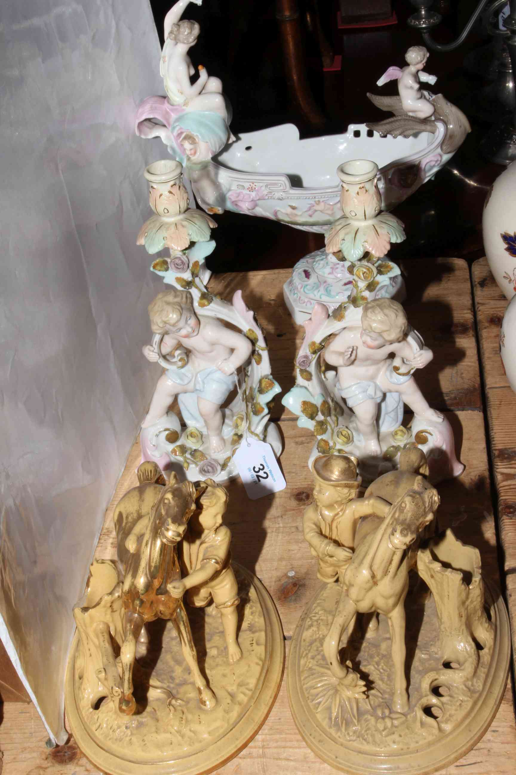 Pair Continental cherub candlesticks and maiden boat vase; pair equestrian figures,