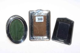 Three small silver mounted easel photograph frames, one embossed with swags, Birmingham 1908,