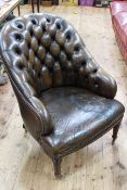 Brown leather deep buttoned back tub chair raised on turned mahogany legs.