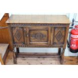 Small carved front oak side cabinet with panelled door, 94cm by 82cm by 36cm.