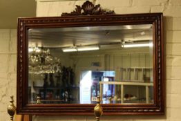 Pair of brass fire dogs with three fire irons, and carved mahogany framed bevelled wall mirror (5).