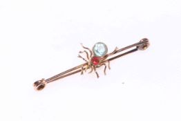 9 carat gold spider brooch set with garnet and blue stone (aqua?), 4.5cm across.