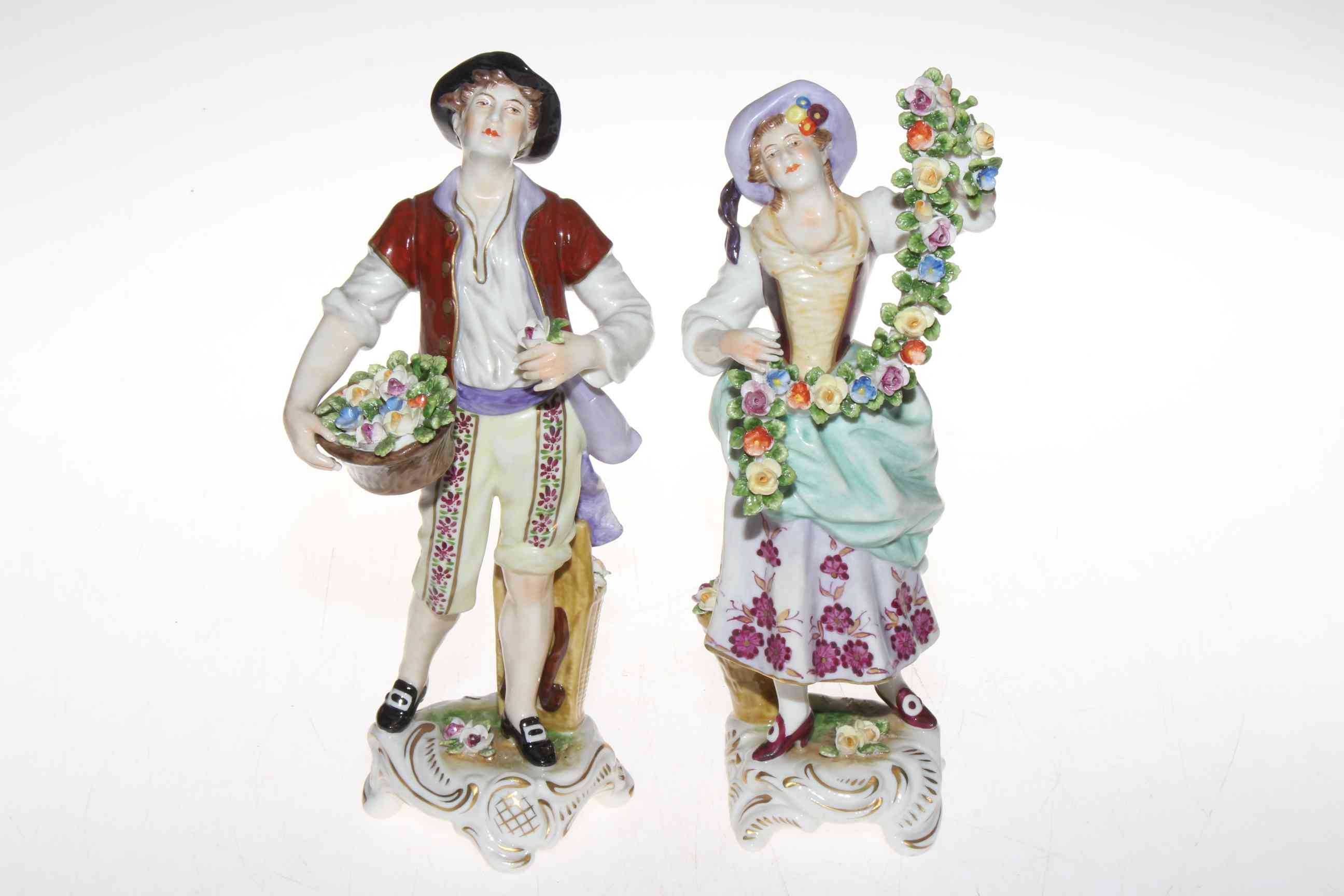 Pair Continental figures of flower vendors, 22.5cm.