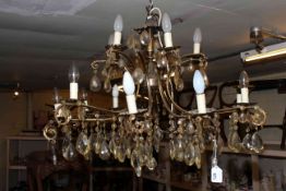 Large gilt metal sixteen branch chandelier with glass tear drop to each branch and cup.