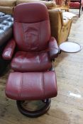 Stressless burgundy swivel adjustable chair and footstool.