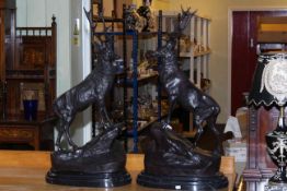 Pair of large impressive bronze stags on rocky outcrops with marble bases, 74cm high.
