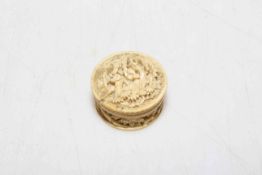 Antique Chinese profusely carved ivory pill box, with figures in outdoor settings, 3.75cm diameter.