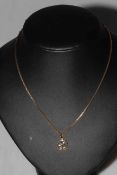 9 carat gold and diamond set foliate pendant with chain, pendant 11mm diameter.