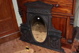 Cast iron arched top framed oval bevelled overmantel mirror, 100cm by 118cm.