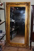 As new ornate gilt framed rectangular bevelled wall mirror, 183cm by 96cm overall.