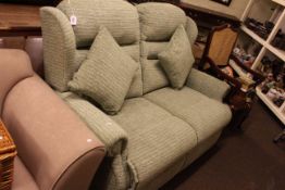 Two seater wing back settee in green fabric.
