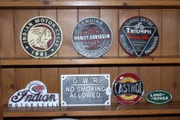 Seven cast metal advert signs including two Indian Motor Cycle signs, Harley Davidson, Triumph, etc.