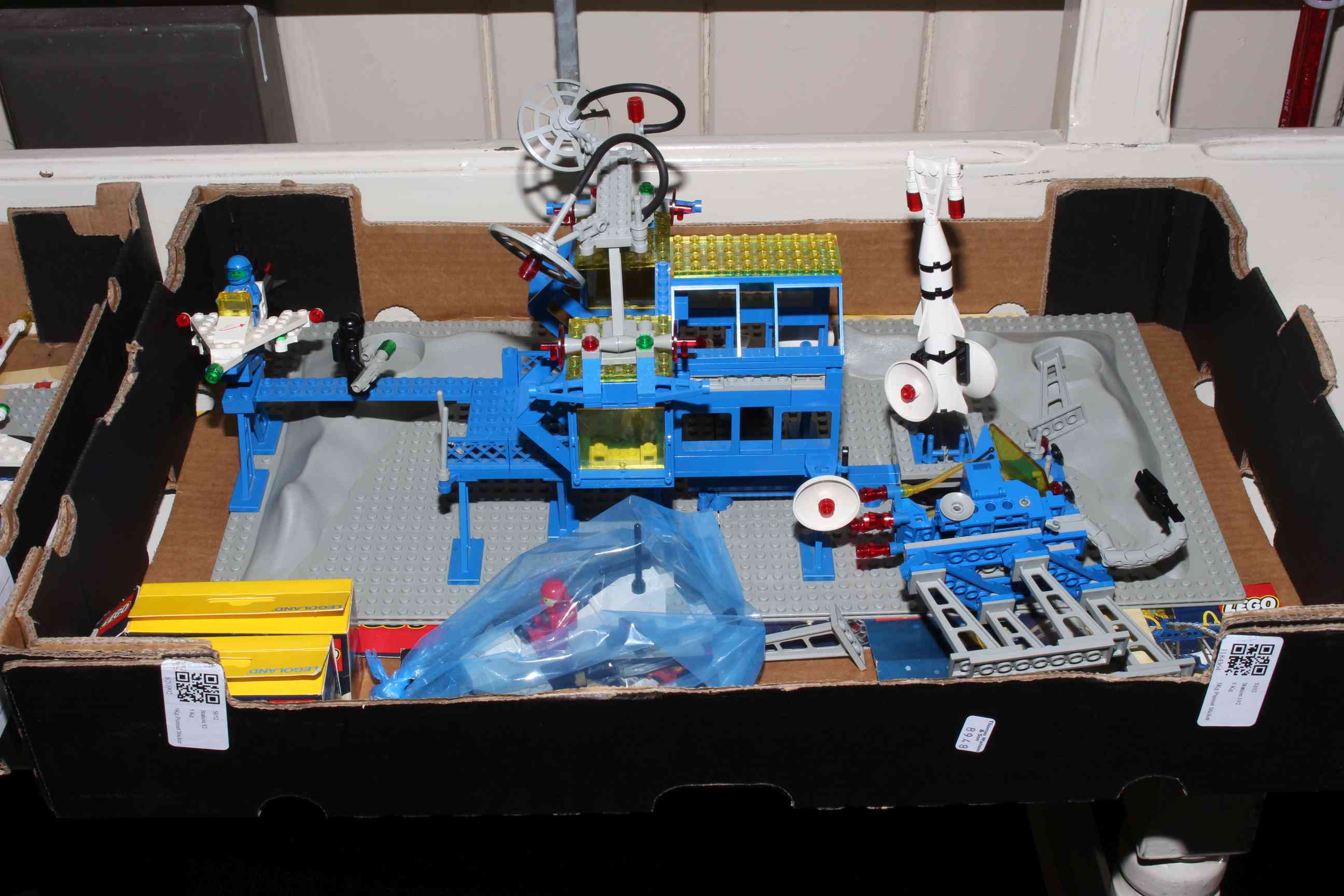 Three Lego kits and accessories, numbers 6971, 6882, 6842, and two figures 1557 and 6804.