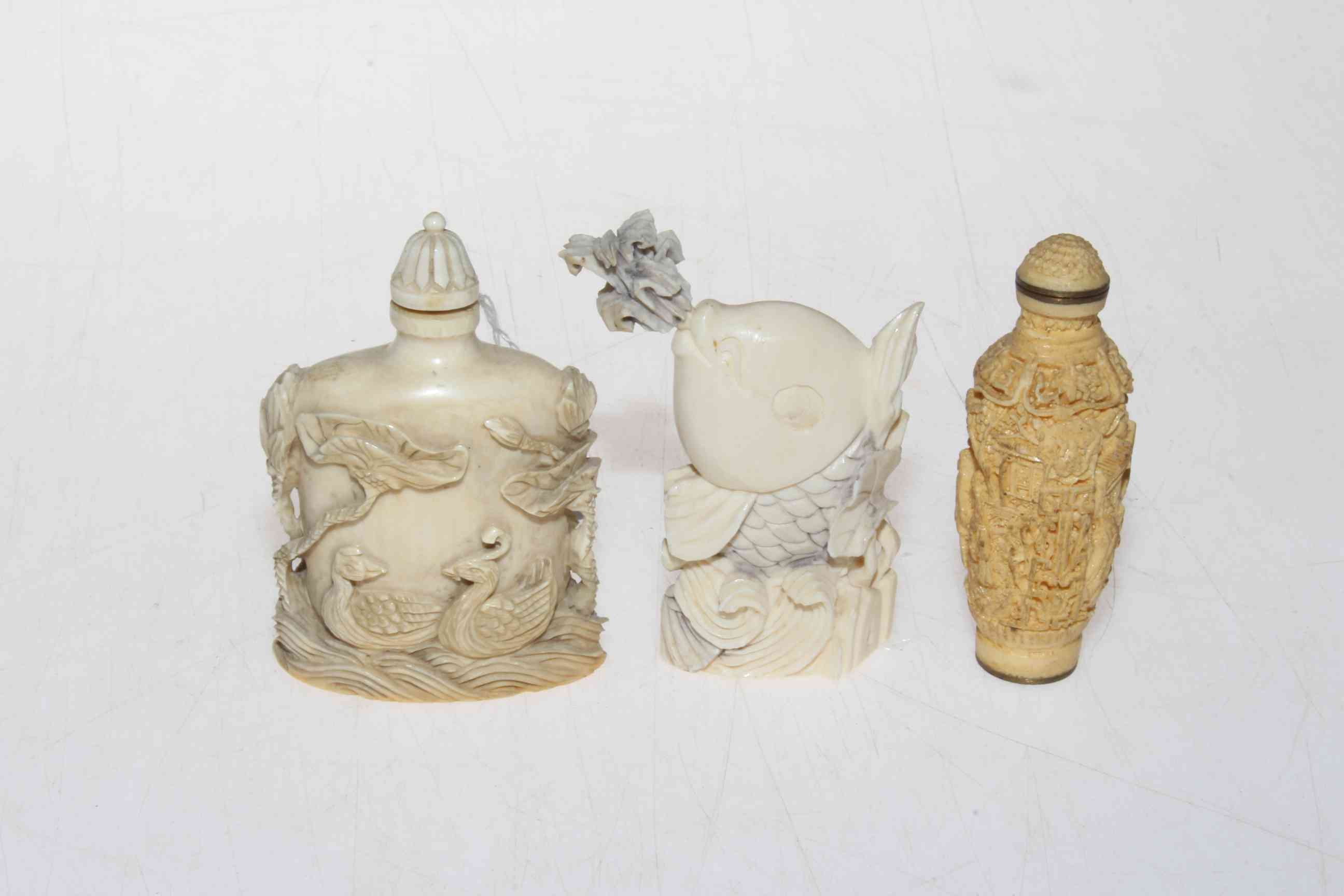 Three ivory/bone scent bottles, each approximately 8cm, all with base signature or mark.