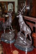 Pair of large impressive bronze models of stags on rocky outcrops raised on marble bases, 74cm high.