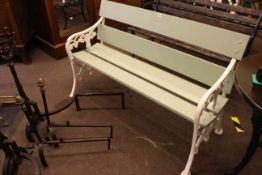 Green and white painted wood slat garden bench with cast ends, 77cm high by 130cm wide by 55cm deep.