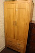 Contemporary light oak wardrobe having double doors above two drawers, 186cm high by 90.