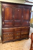 Georgian oak wardrobe having three arched fielded panel doors above four long and two short drawers,