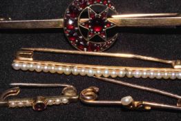 Four early 20th Century brooches, three set with seed pearls, largest 5.6cm across.