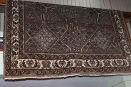 Persian design wool carpet with a brown ground, 3.10 by 2.05.