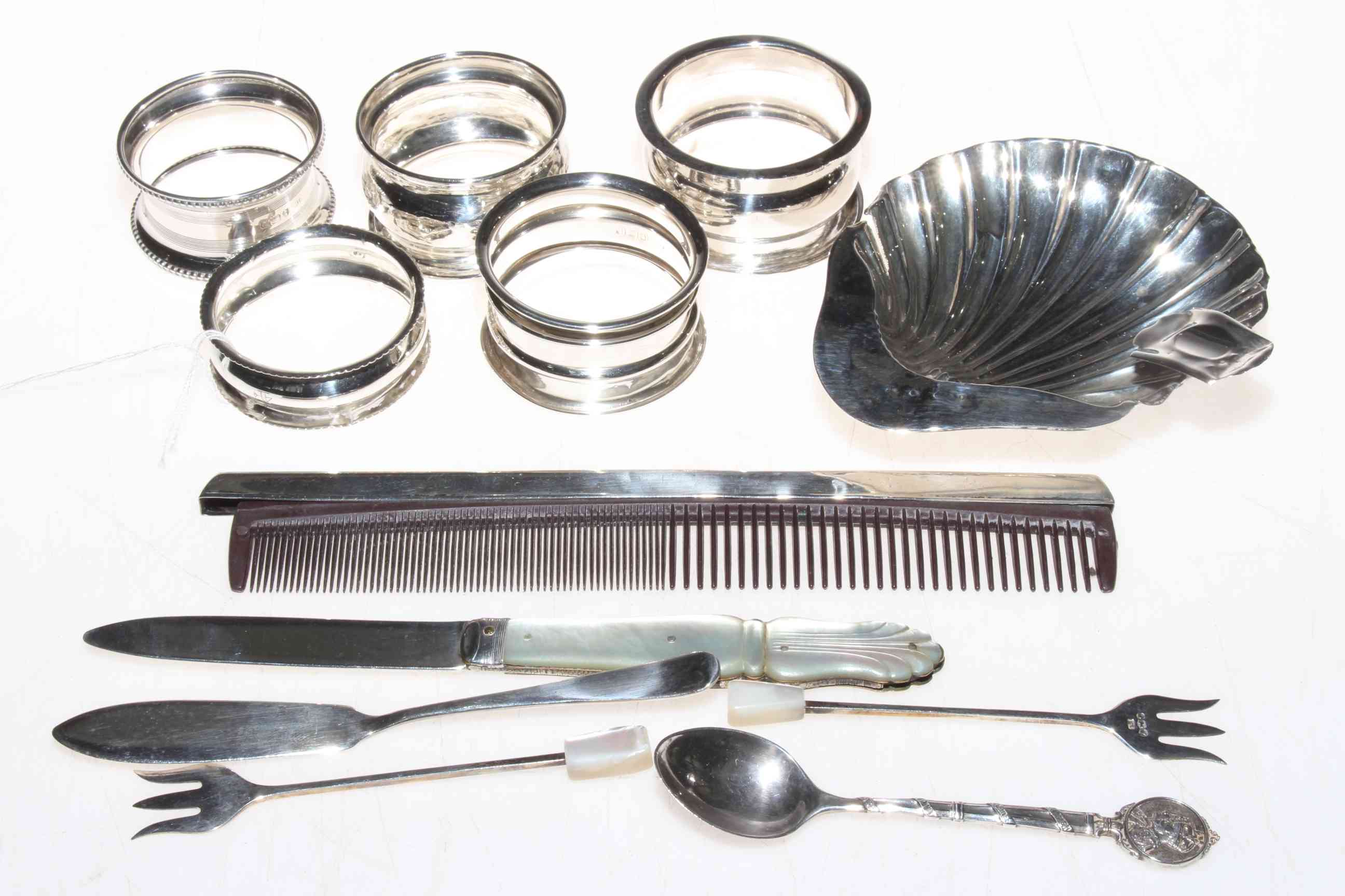 Silver pieces comprising folding fruit knife, five napkin rings, two sardine forks, butter knife,