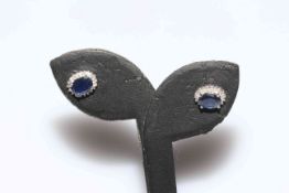 Pair of oval sapphire earrings set in 14 carat white gold.