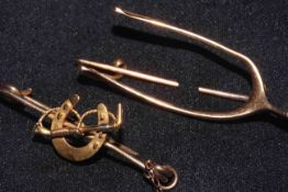 Two 15 carat gold brooches, one wishbone shaped 3.8cm, and the other with horseshoe and crop, 3.