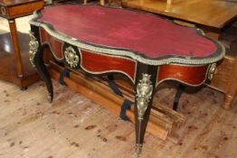 French ebonised and gilt metal mounted bureau plat, of oval shape with inset red leather,