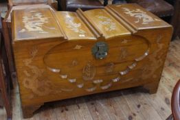 Oriental camphorwood trunk with dragon and floral decoration, 57cm high by 102cm wide by 51cm deep.