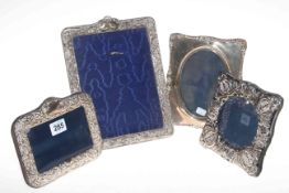 Collection of four embossed silver photograph frames, largest 25cm by 19cm.