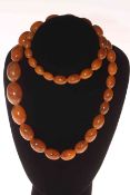 Tan coloured amber necklace of graduated oval beads, 70cm length.