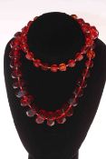 Red amber necklace of graduated faceted beads, 70cm length.