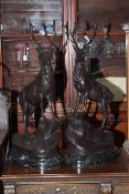 Pair of large impressive bronze models of stags on rocky outcrops, raised on marble bases,