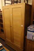 Ercol contemporary light oak wardrobe having two doors above a base drawer,