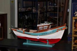 Wooden fishing boat with accessories on stand, 90cm by 63cm by 28cm.