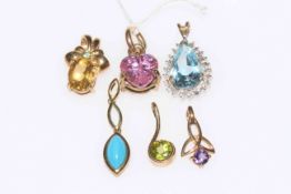 Six 9 carat gold gem set pendants.