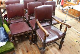 Set of seven 1920's/30's oak framed dining chairs in studded hide including one carver.
