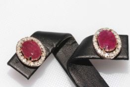 Ruby and diamond earrings set in 14k rose gold, each having oval cut ruby approximately 3.