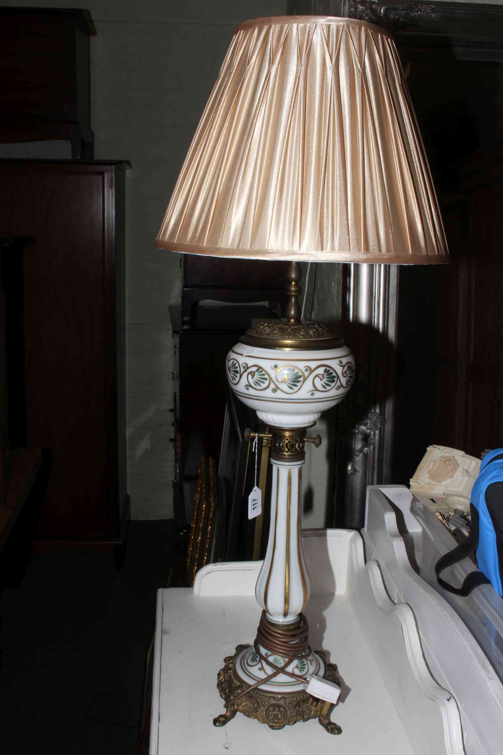 Ornate gilt metal and opaque glass lamp converted to electricity, 92cm high with shade.