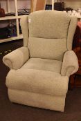 Manual reclining wing easy chair in light green fabric.