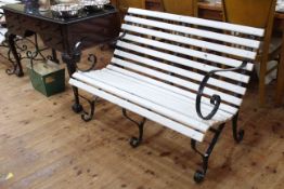 Wrought iron and wood slat scroll arm two seater garden bench, 79cm high by 115cm wide.