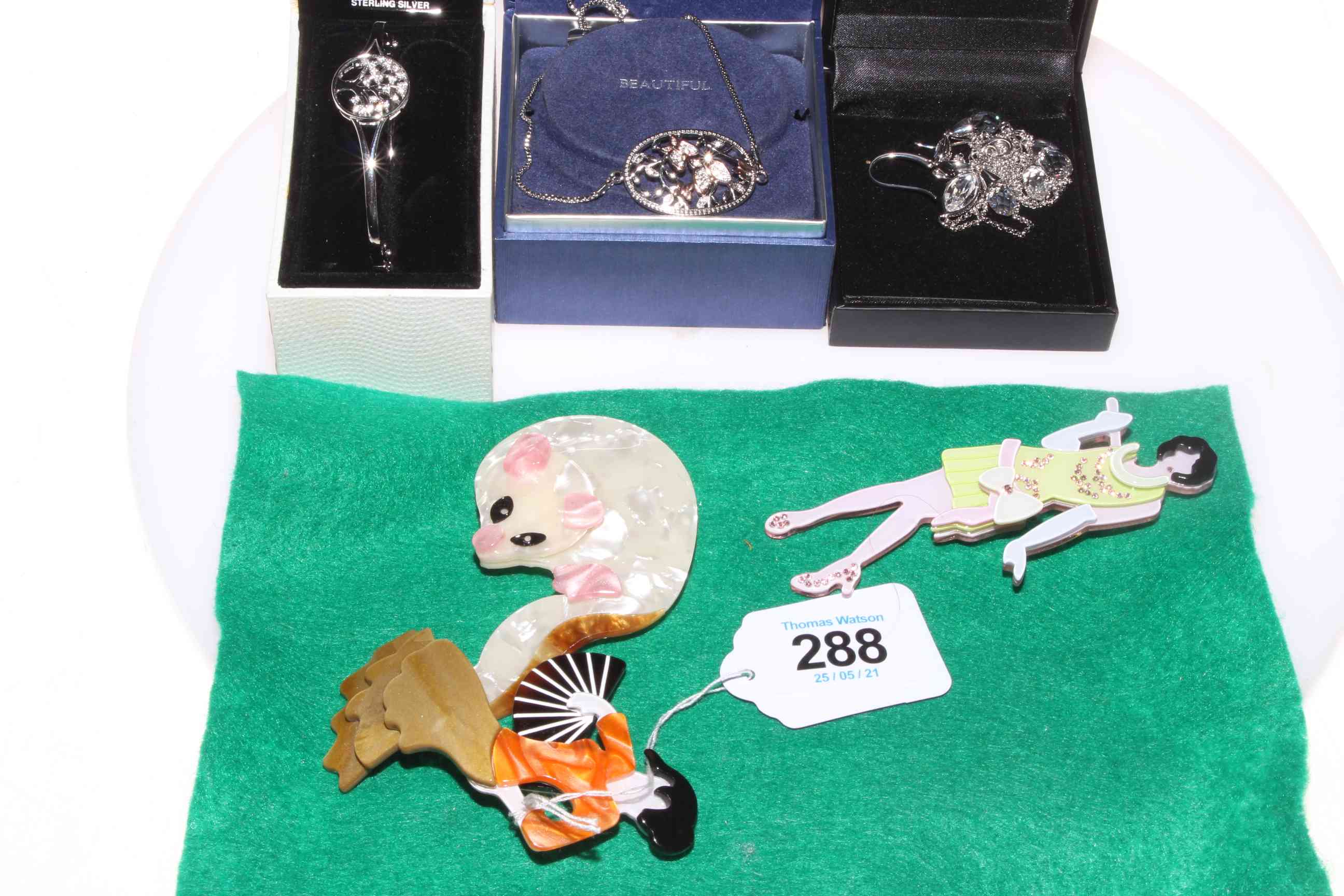Three boxed pieces of silver jewellery and three Kitch brooches.