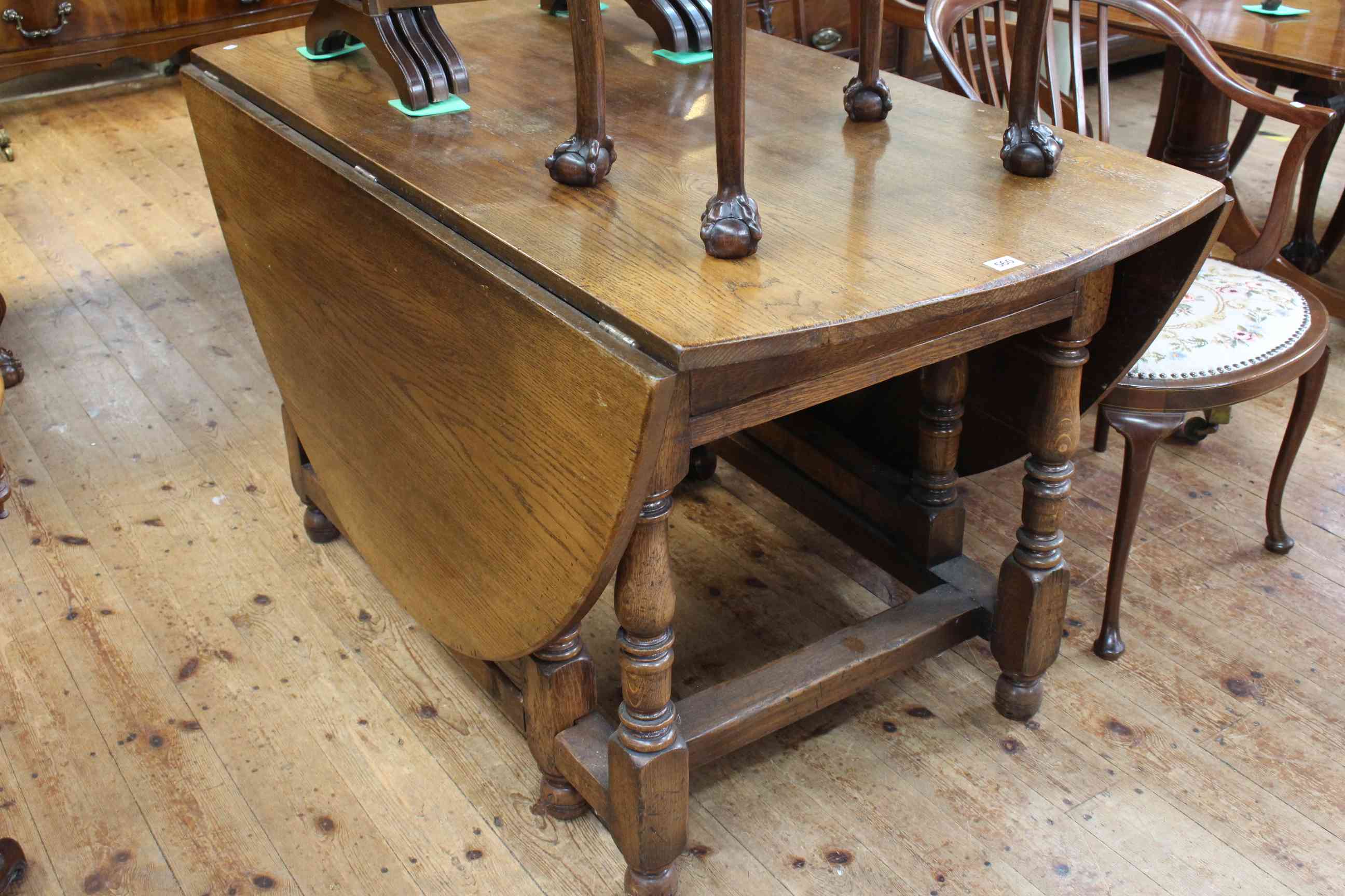 Large oak gate leg dining table having two frieze drawers and raised on turned legs,