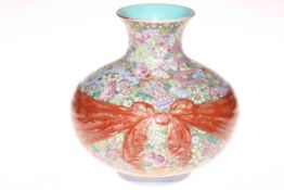 Chinese porcelain vase of onion form with iron red and gilt bow tied sash on profusely decorated