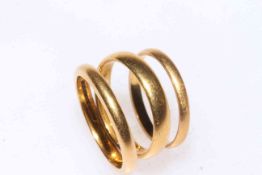Three 22 carat gold band rings.